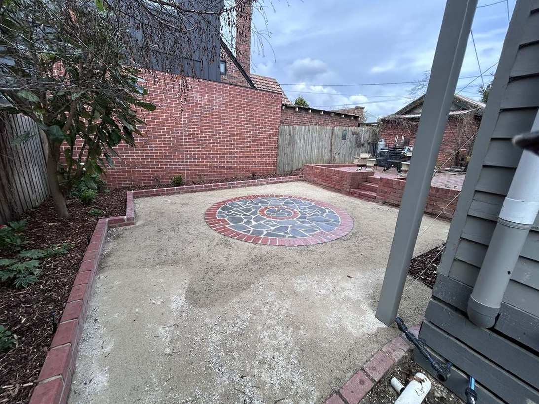 Circular mosaic feature with brick edging